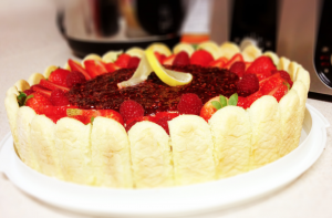 Cake wrapped in ladyfingers with strawberries