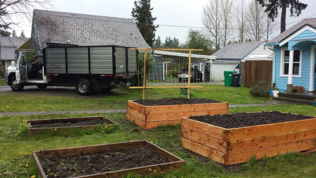 The first garden build I've helped with this year was a unique one, as the gardener received essentially double what we normally provide. They have received beds from us in the past, pictured on the left. For accessibility's sake they requested triple stacked beds this time around. The VGP Beast dump truck is in the background, which allows us to haul about two tons of soil and supplies. We had to make two trips for this build. 