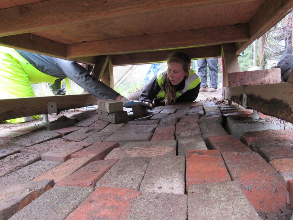 Katherine, my field supervisor, laying the bricks with the help of a youth crew member.