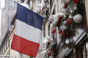 A French flag hangs from a window of a restaurant decorated for Christmas holiday season in Strasbourg, France, November 27, 2015 after the French President called on all French citizens to hang the tricolour national flag from their windows to pay tribute to the victims of the Paris attacks during a national day of homage. REUTERS/Vincent Kessler