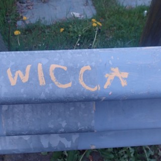 "Wicca" written in yellow on a guard rail