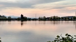 Lake reflecting sunset with buildings in the distance