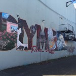 View of "Olympia" graffiti mural in alleyway.